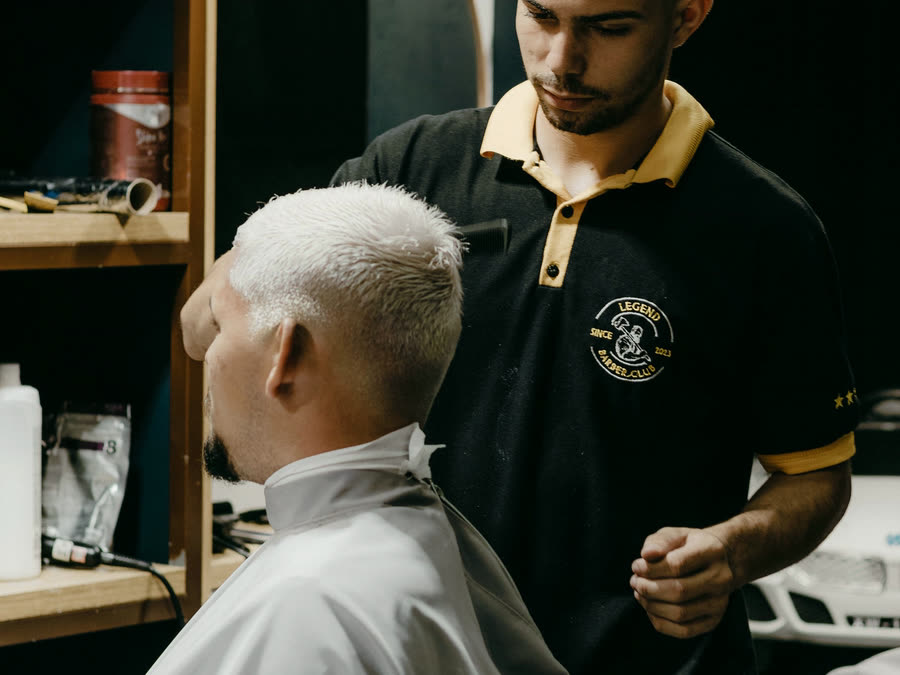 Barberare som arbetar med en kund i barberarstolen